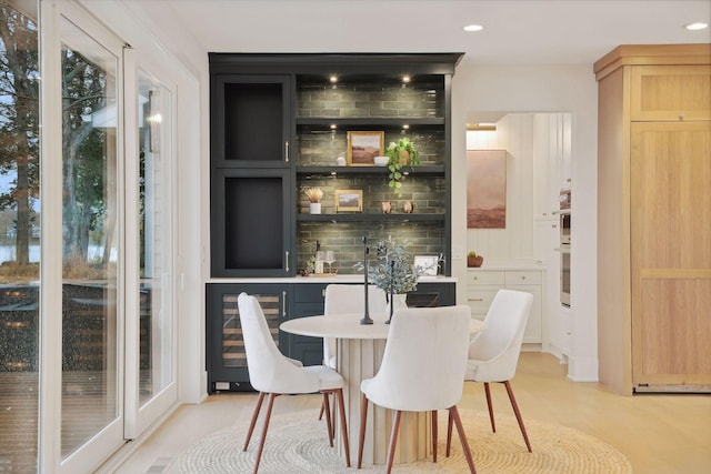 bar featuring light brown cabinets, a wealth of natural light, and wine cooler