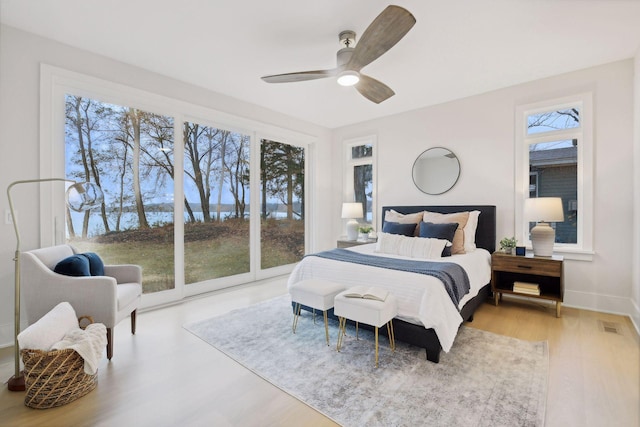 bedroom with light hardwood / wood-style floors, multiple windows, and ceiling fan