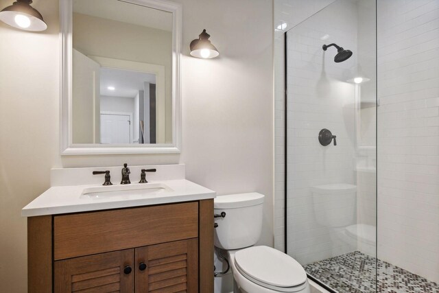 bathroom featuring toilet, vanity, and walk in shower