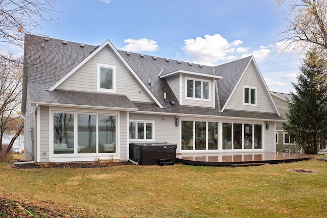 back of house with a hot tub and a lawn