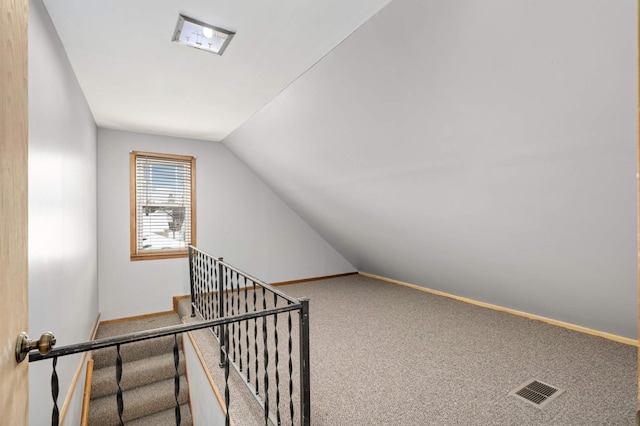 interior space featuring vaulted ceiling and carpet flooring