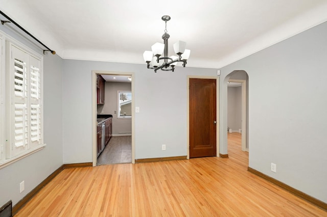 unfurnished dining area featuring a healthy amount of sunlight, a chandelier, and light wood-type flooring