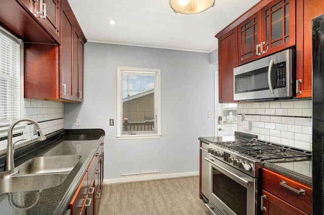 kitchen featuring stainless steel appliances, ornamental molding, sink, and decorative backsplash