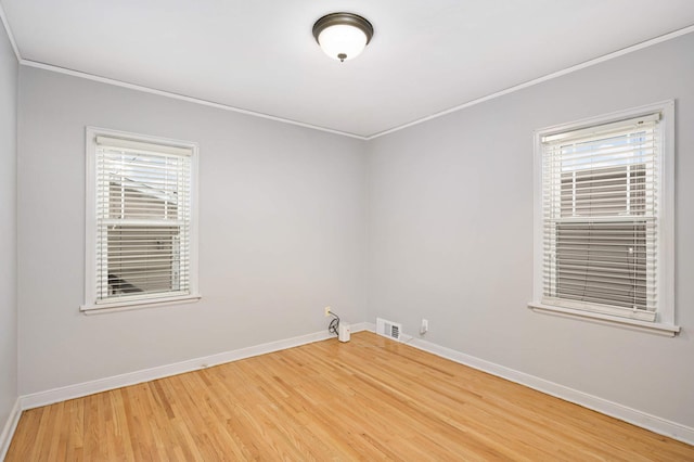 empty room featuring hardwood / wood-style flooring and crown molding