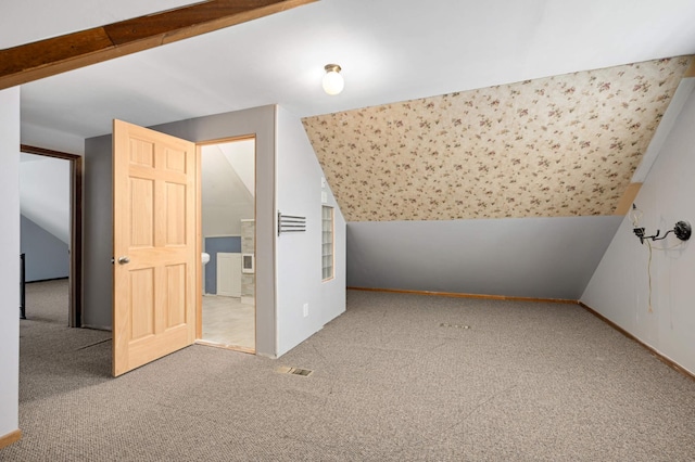 additional living space featuring carpet floors and vaulted ceiling