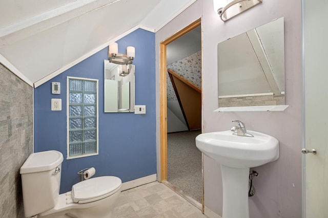 bathroom featuring sink, toilet, and vaulted ceiling