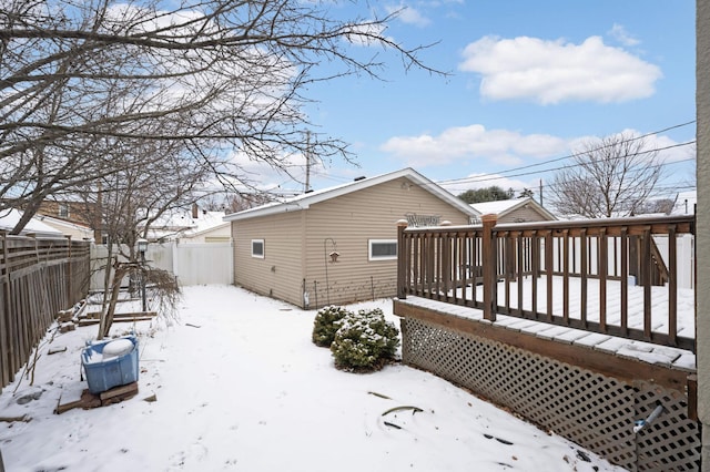 snow covered house with a wooden deck