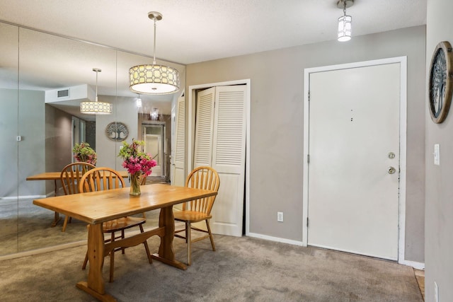 carpeted dining area featuring a textured ceiling