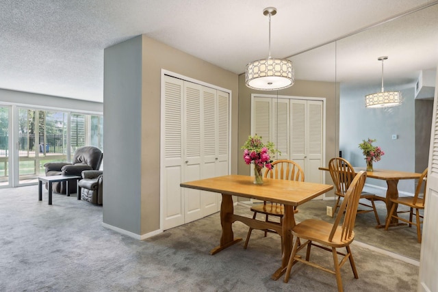 carpeted dining room featuring a textured ceiling