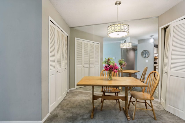 dining area featuring a textured ceiling and dark colored carpet