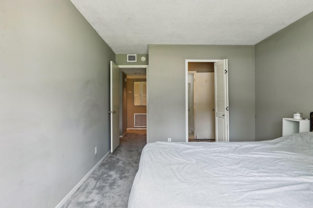 bedroom with a textured ceiling and light colored carpet