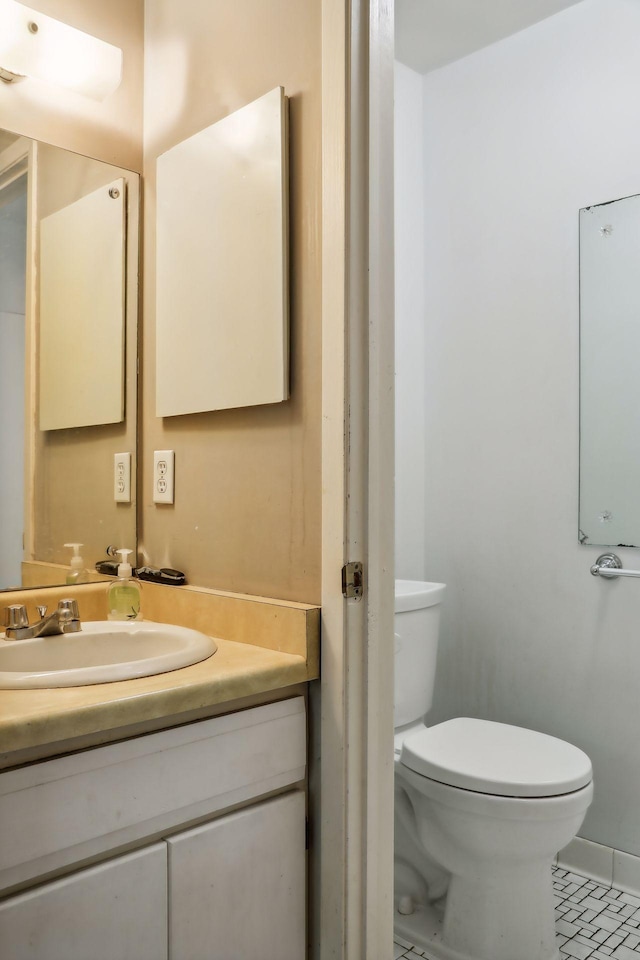 bathroom with vanity, toilet, and tile patterned flooring