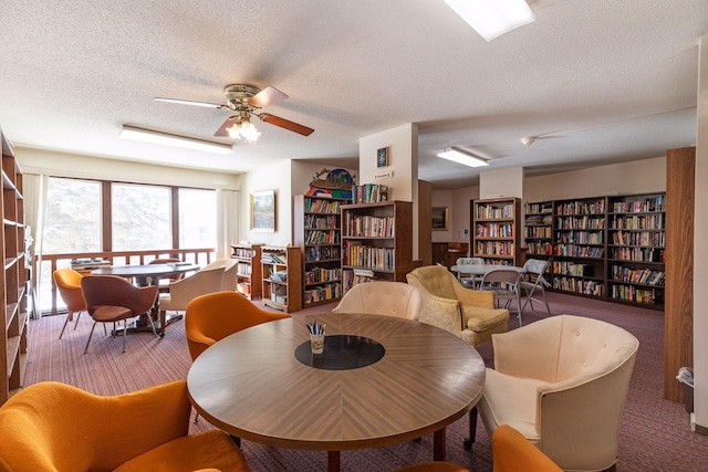 dining room with a textured ceiling, carpet, and ceiling fan