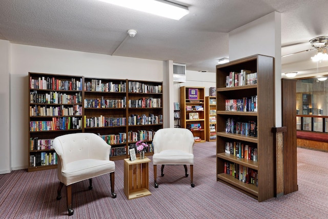 living area featuring carpet and a textured ceiling