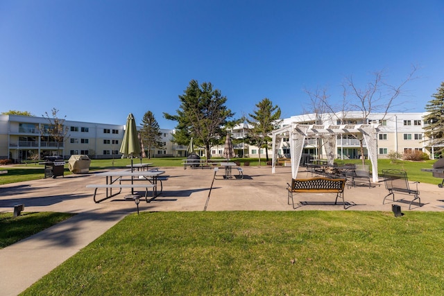 view of community featuring a lawn and a pergola