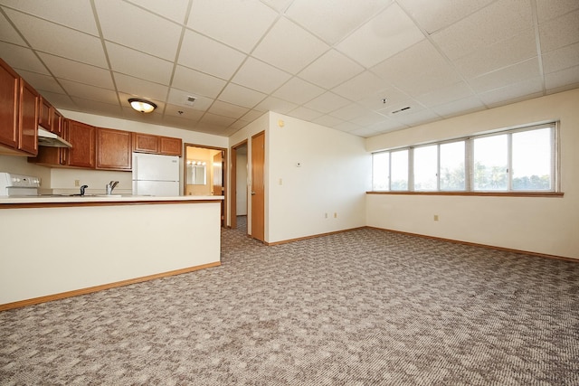 kitchen with range, a drop ceiling, carpet flooring, and white refrigerator