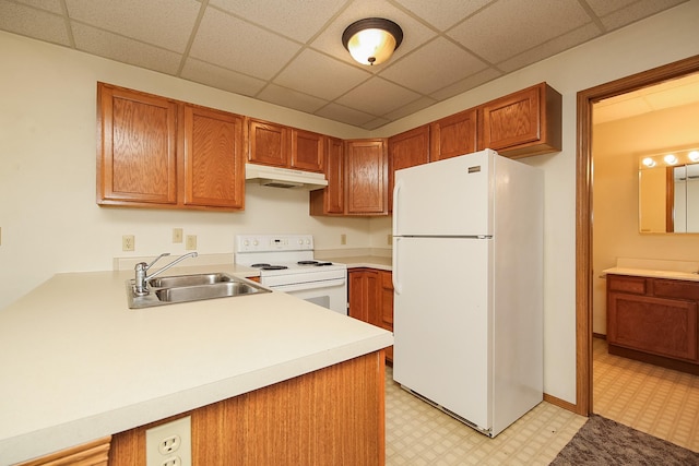 kitchen featuring sink, a drop ceiling, kitchen peninsula, and white appliances