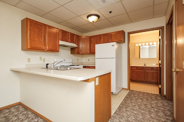 kitchen featuring white appliances, a paneled ceiling, and kitchen peninsula