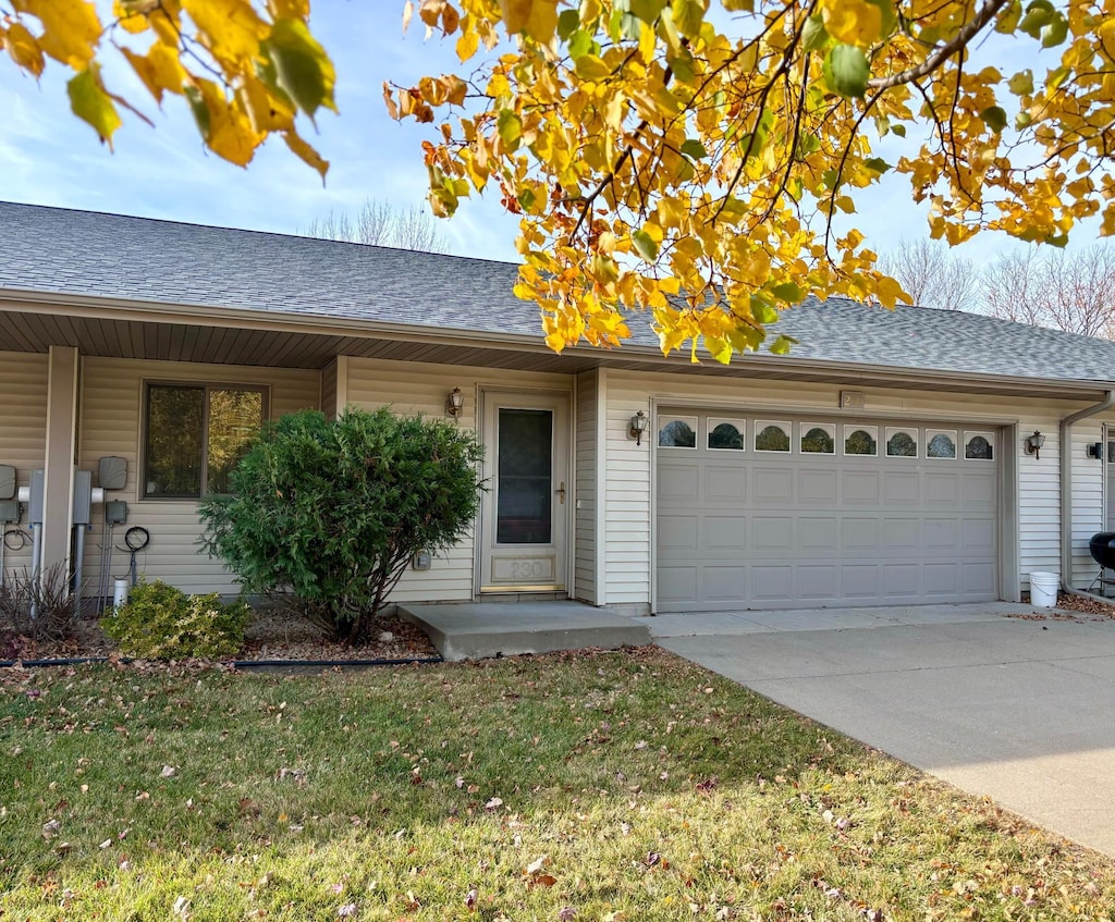 ranch-style house featuring a front yard and a garage