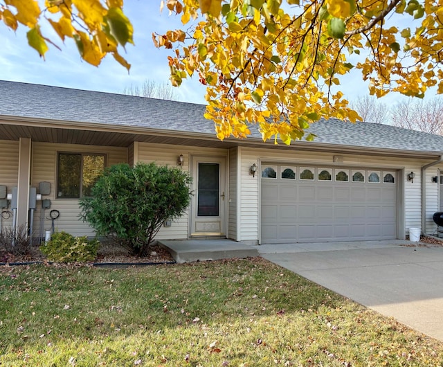 ranch-style house featuring a front yard and a garage