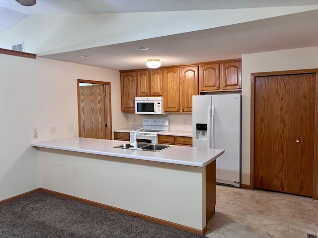 kitchen with lofted ceiling, sink, kitchen peninsula, and white appliances