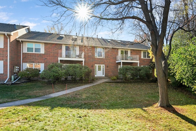 view of front of house with a balcony and a front yard