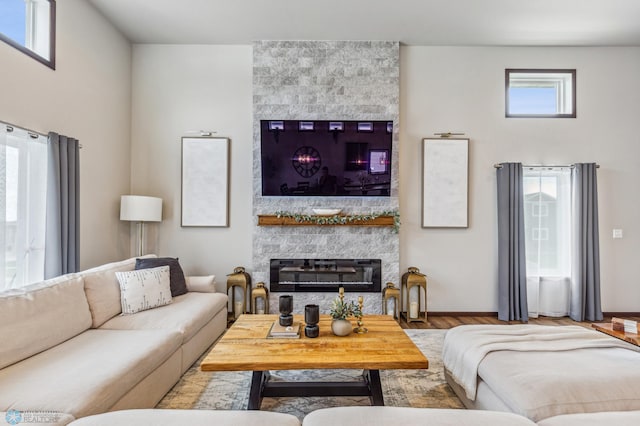 living room featuring light wood-type flooring, a fireplace, and a wealth of natural light