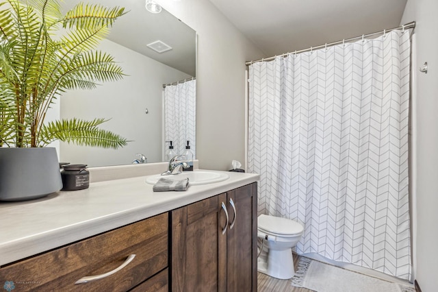 bathroom featuring hardwood / wood-style floors, vanity, and toilet