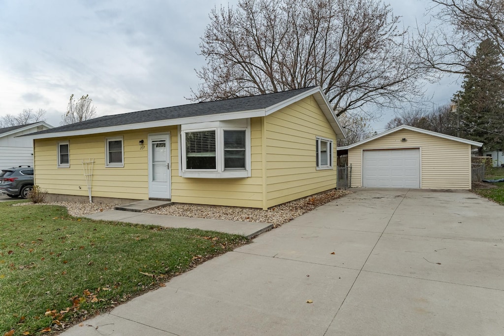 ranch-style home with an outbuilding, a front lawn, and a garage