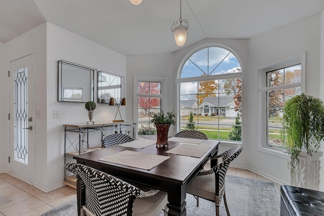 tiled dining space featuring lofted ceiling