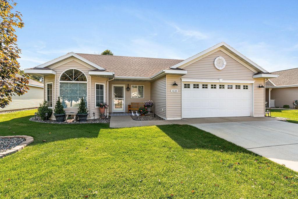 single story home featuring a garage and a front yard