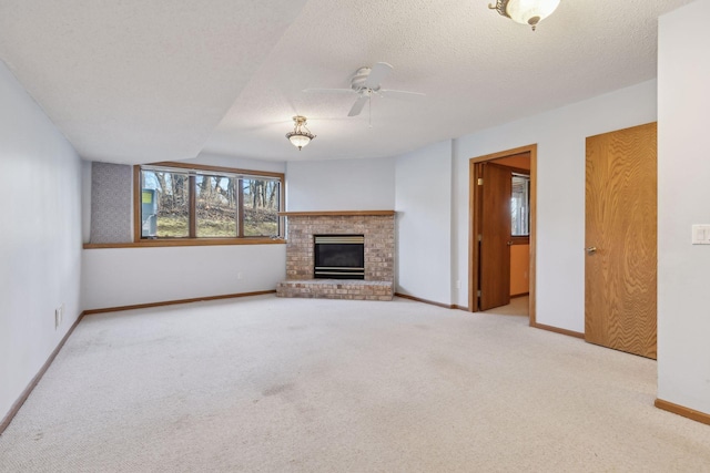 unfurnished living room featuring a brick fireplace, a textured ceiling, light colored carpet, and ceiling fan