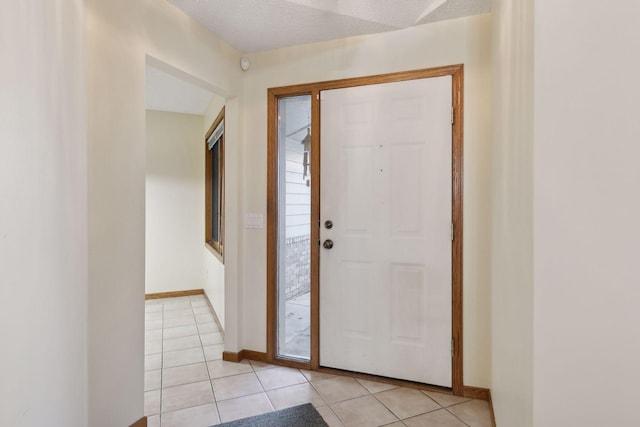 foyer featuring a textured ceiling and light tile patterned floors