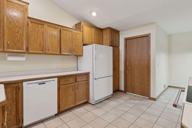 kitchen with white appliances, lofted ceiling, and light tile patterned floors