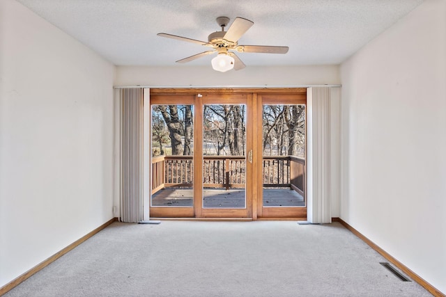 carpeted spare room featuring ceiling fan and a textured ceiling