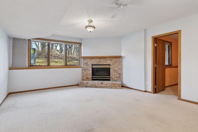 unfurnished living room with a fireplace, light colored carpet, ceiling fan, and a textured ceiling