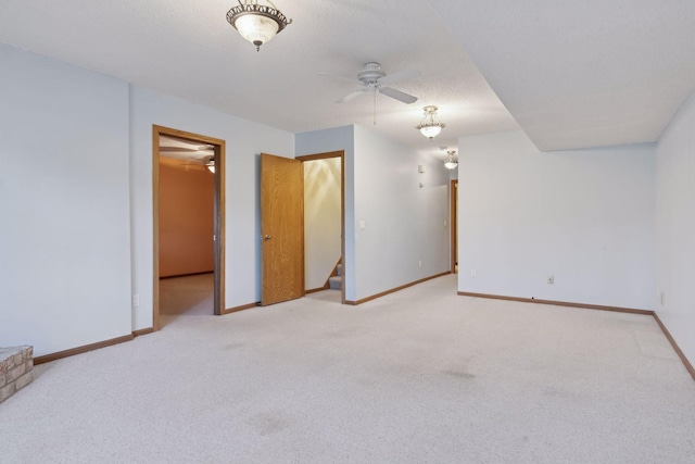 spare room with ceiling fan, light carpet, and a textured ceiling