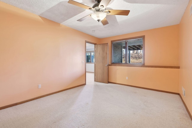 carpeted spare room with a textured ceiling and ceiling fan