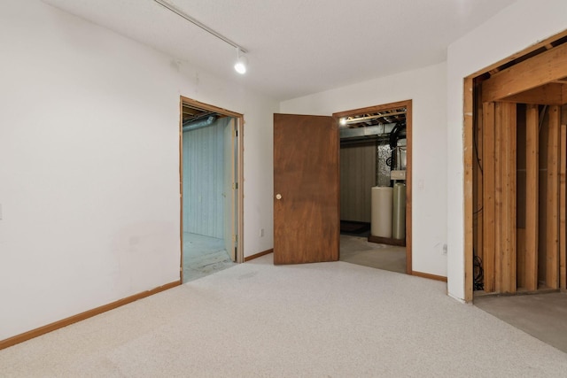 unfurnished bedroom with light colored carpet, a closet, and track lighting