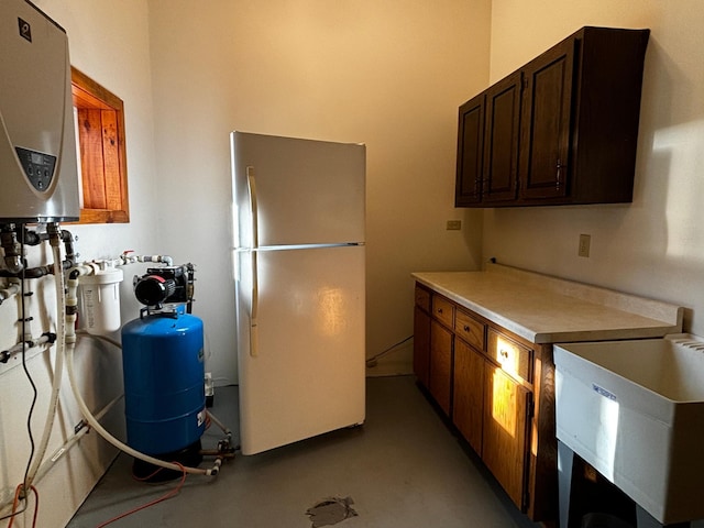 kitchen with concrete floors, water heater, and white refrigerator