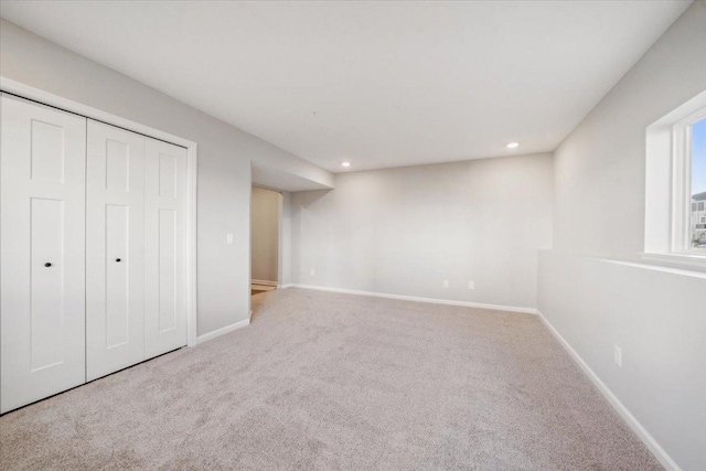 unfurnished bedroom with light colored carpet and a closet