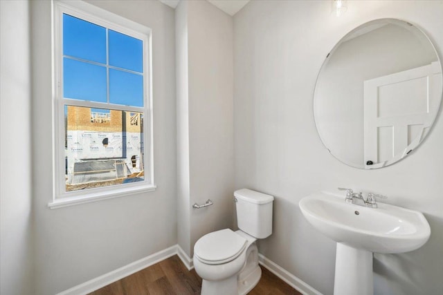 bathroom with plenty of natural light, toilet, and wood-type flooring