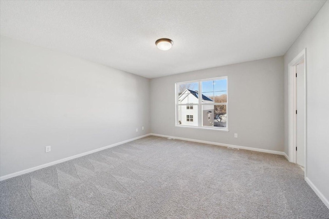 carpeted spare room with a textured ceiling