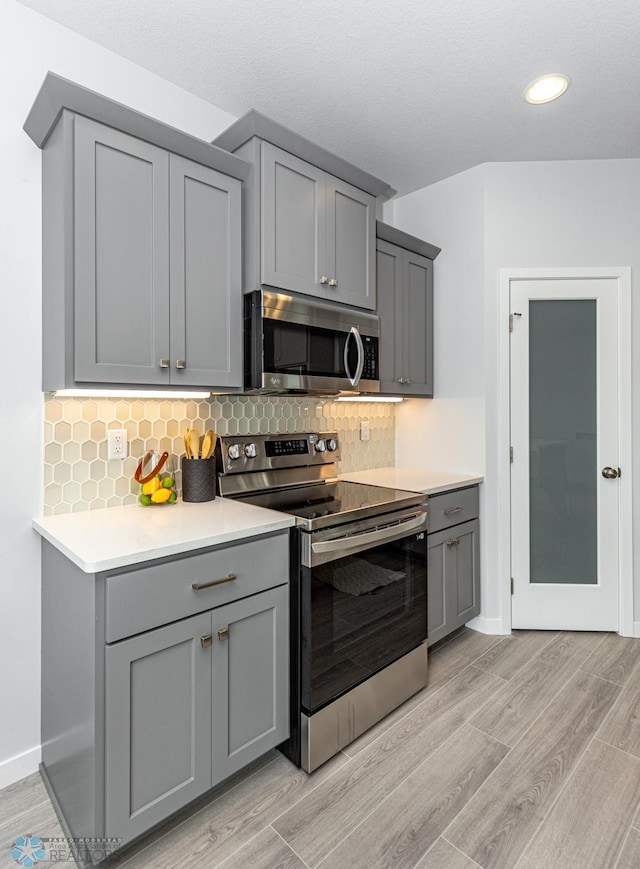 kitchen with gray cabinets and stainless steel appliances