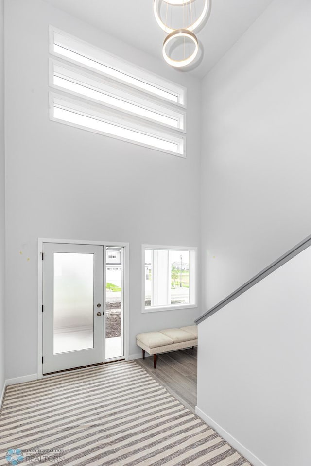 foyer with a towering ceiling and light carpet