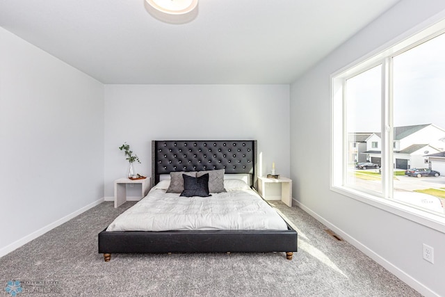 bedroom with multiple windows, carpet floors, and baseboards