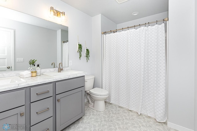 full bathroom featuring double vanity and toilet