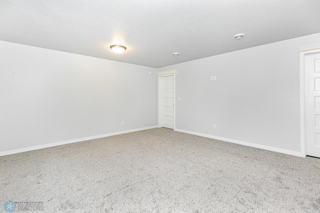 empty room with carpet and a textured ceiling