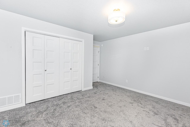 unfurnished bedroom with carpet floors, a closet, and baseboards