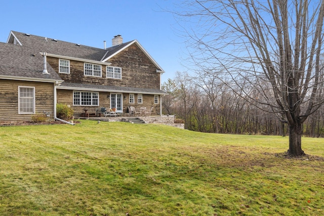 back of property with a yard and a chimney